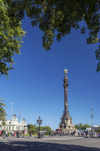 Statue in city against clear blue sky