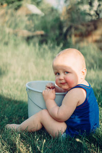 Cute baby boy sitting on field