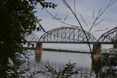 Arch bridge over river against sky