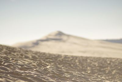 Close-up of sand dune against clear sky