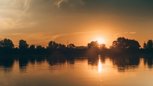 Scenic view of lake against orange sky