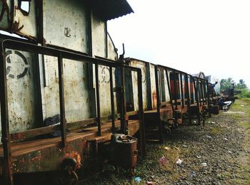 Abandoned train on railroad track against sky