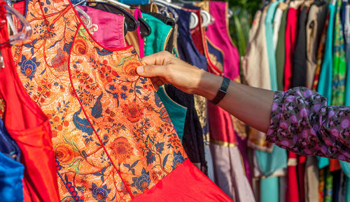 Cropped image of hand choosing dress at market