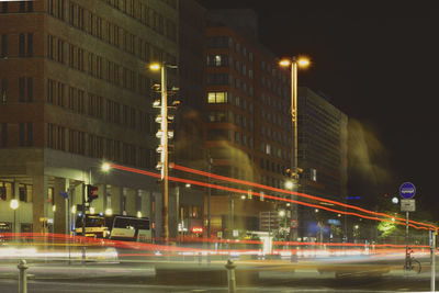 Light trails on road along buildings at night