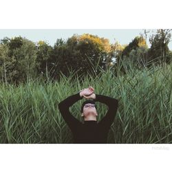 Man wearing sunglasses on grass against sky