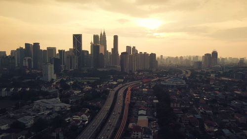 Aerial view of buildings in city against sky during sunset