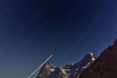 Low angle view of vapor trails in sky at night