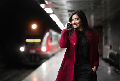 Portrait of beautiful woman standing at railway station