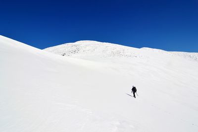 Person skiing on snowcapped mountain against sky
