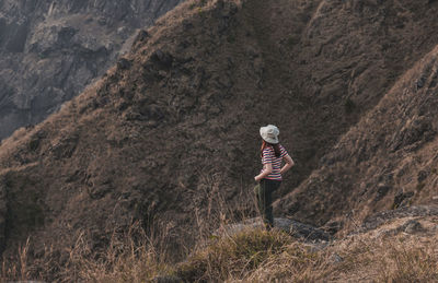 Rear view of person walking on rock