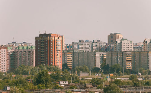 Buildings in city against clear sky