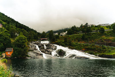 Scenic view of waterfall against sky