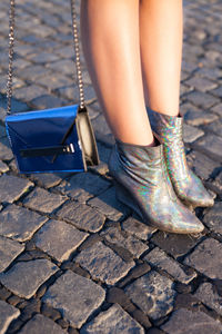 Low section of woman standing on footpath