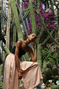 Portrait of smiling young woman standing against plants