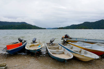 Boats moored in lake against sky