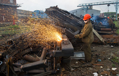 Worker welding scrap metal