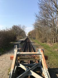 Railroad tracks on field against clear sky