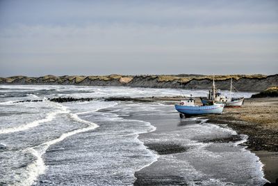 Boat moored on sea against sky