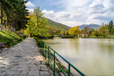 Rear view of man standing by lake against sky