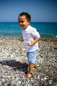 Happy kid in white shirt and blue shorts.