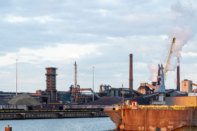 Ships at commercial dock on sea against sky