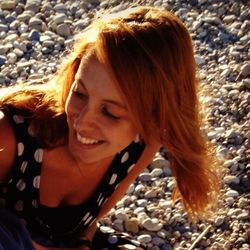 Portrait of smiling young woman with pebbles