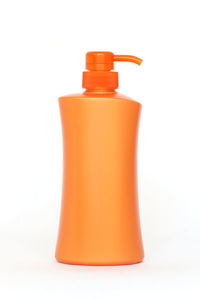 Close-up of orange bottle against white background
