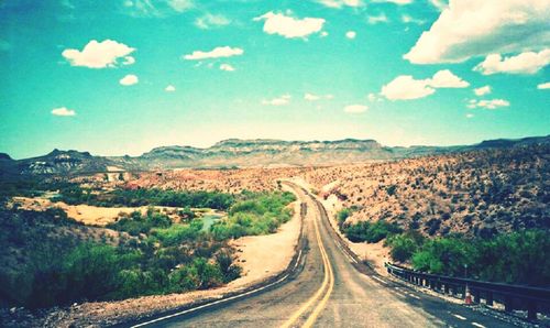 Empty road along countryside landscape