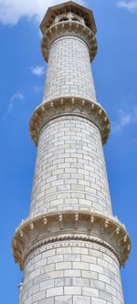 Low angle view of lighthouse by building against sky