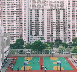 High angle view of people in swimming pool against buildings in city