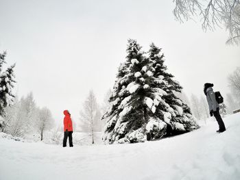 Rear view of people walking on snow covered land