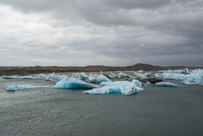 Ice floating on sea against sky