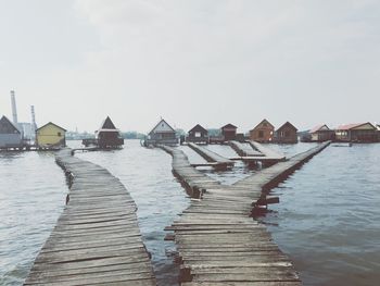 Houses on lake against sky