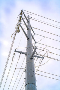 Low angle view of electricity pylon against sky