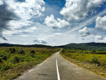 Empty road along countryside landscape