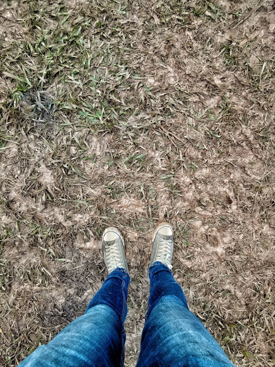 LOW SECTION OF PERSON STANDING ON FIELD
