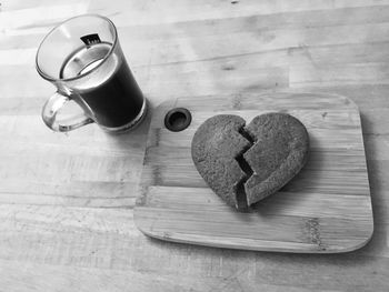 High angle view of heart shape cookie by coffee on table