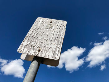 Low angle view of telephone pole against blue sky