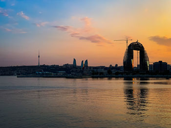 View of buildings at waterfront during sunset