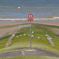 High angle view of road sign by sea