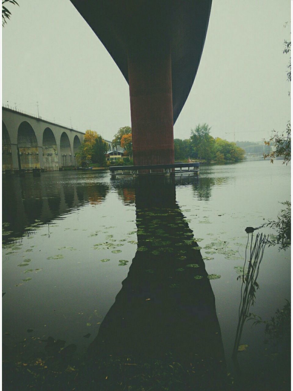 water, architecture, reflection, built structure, building exterior, river, bridge - man made structure, connection, lake, waterfront, standing water, canal, clear sky, bridge, arch, auto post production filter, outdoors, sky, day, tree