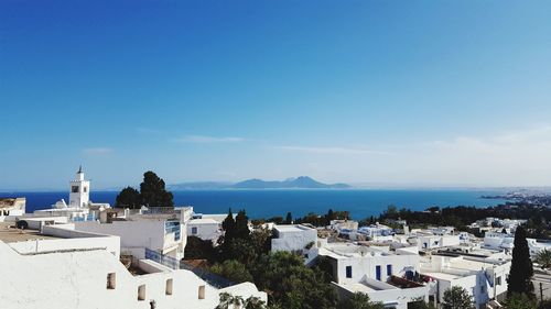 High angle view of houses by sea against sky