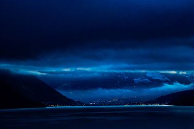 Scenic view of sea against storm clouds at night