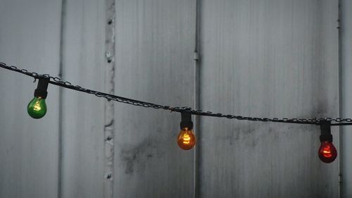 Low angle view of lighting decoration hanging against wooden wall