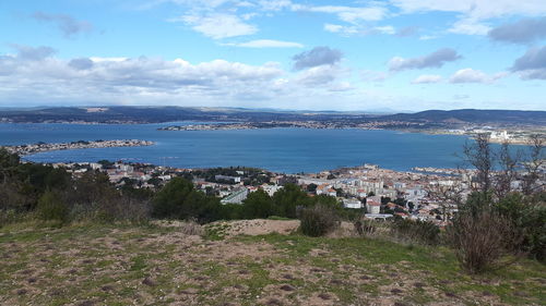 Scenic view of sea by buildings against sky