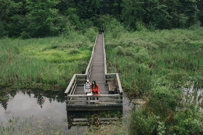 A young couple enjoys a hike on a boardwalk in the pacific northwest.