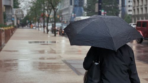 Man walking on wet street during rainy season