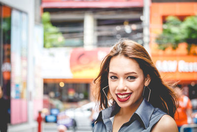 Close-up portrait of happy young woman in city