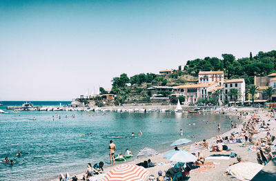 People on sea against clear sky