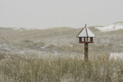 Close-up of snow on field against sky